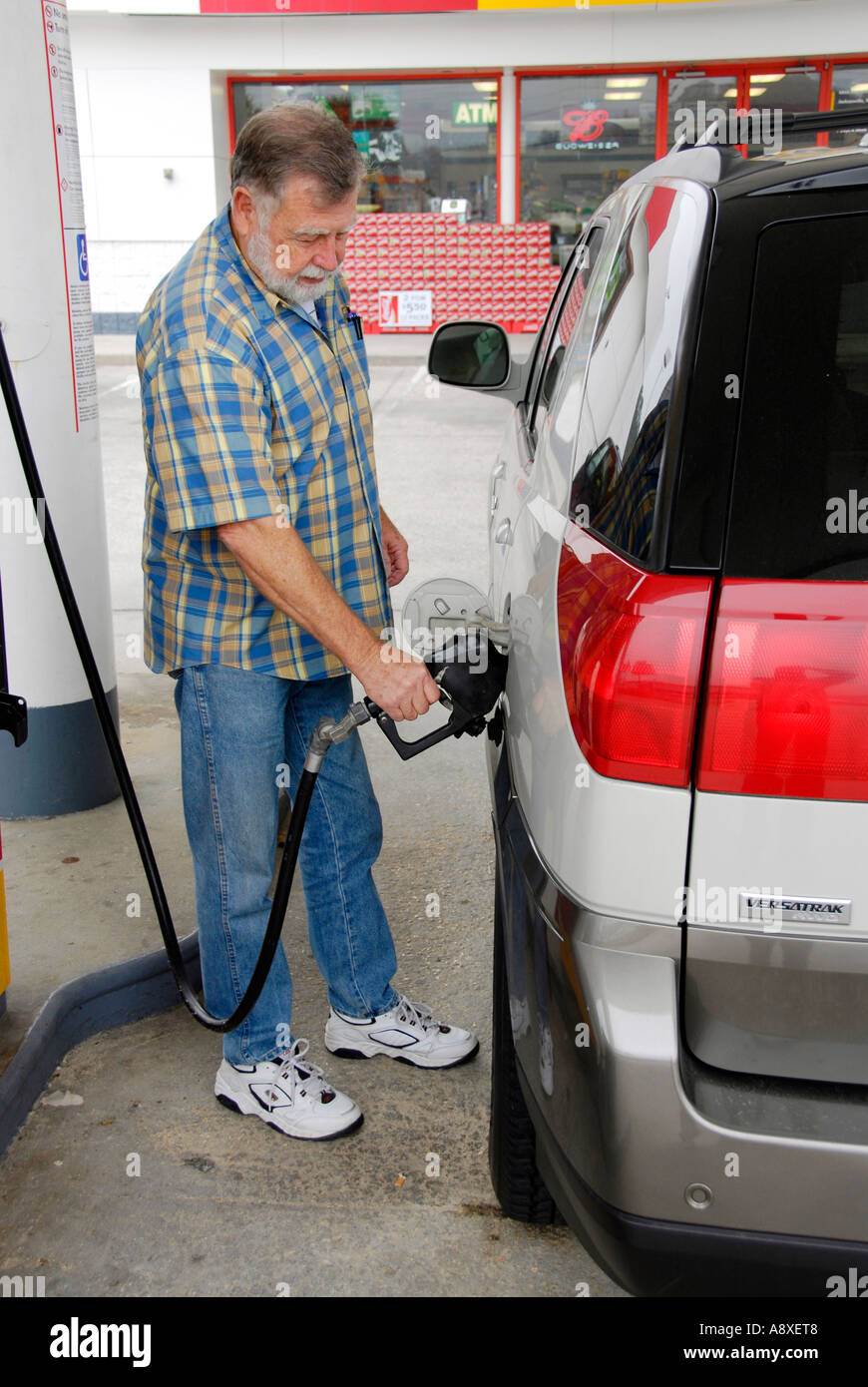 Adult male pumps gas into his car at a gas station Stock Photo Alamy