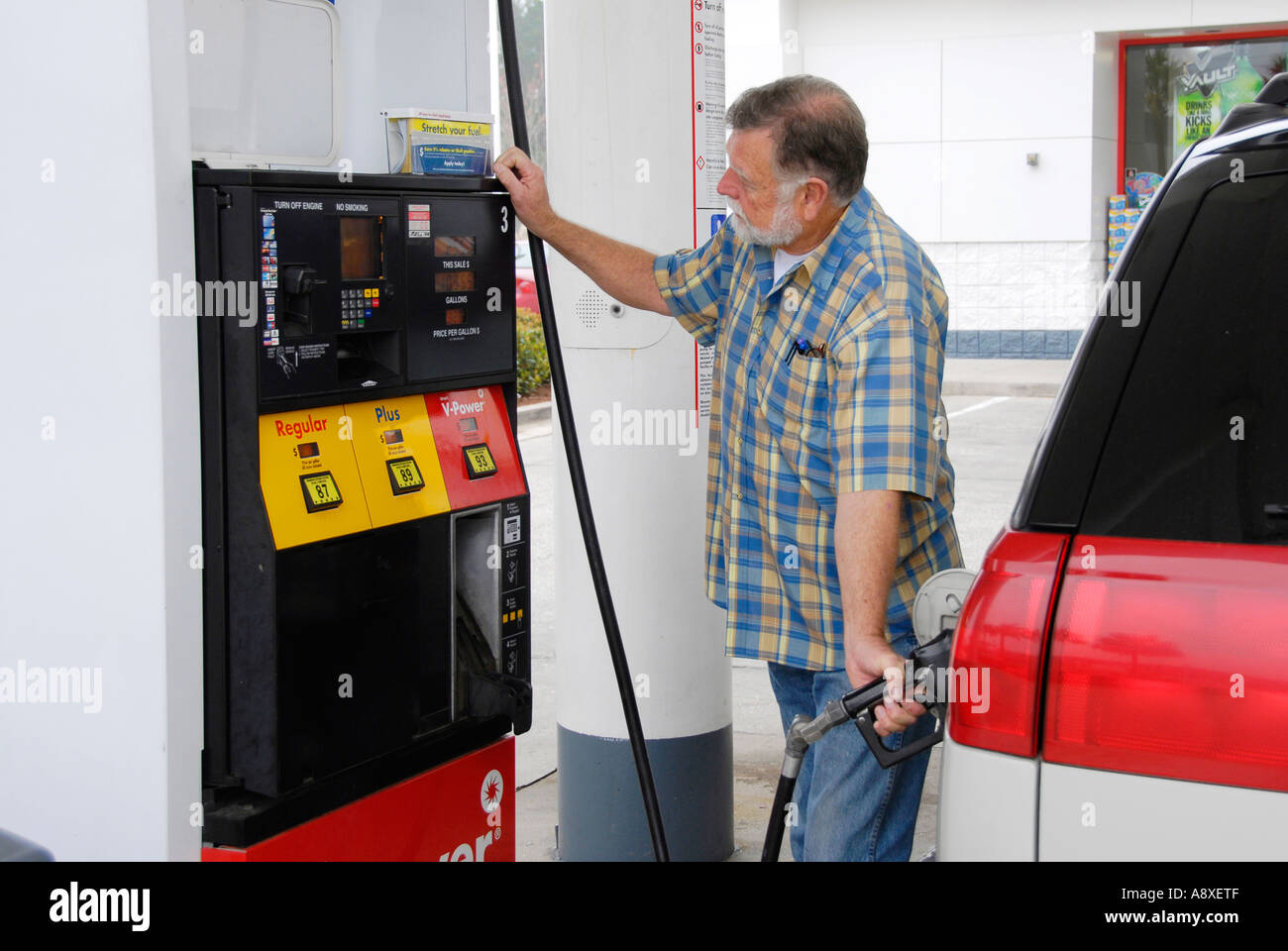Adult male pumps gas into his car at a gas station Stock Photo Alamy