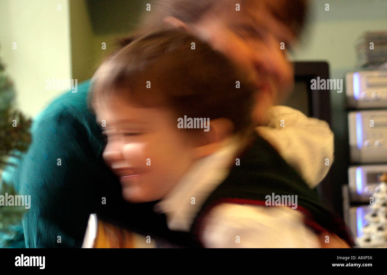 a motion blurred image of a five year old boy cuddling a thirty year old woman Stock Photo