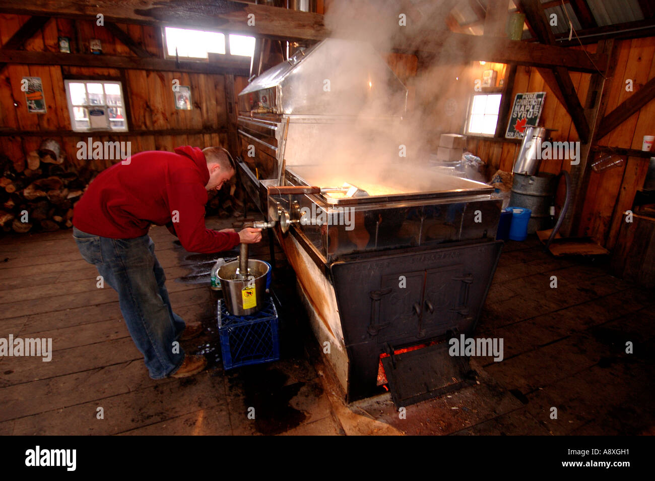 A farmer works the Maple Syrup evapurator Stock Photo Alamy