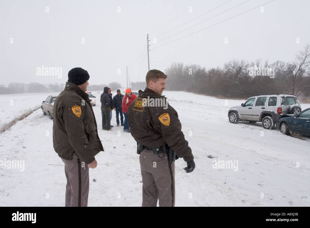 Deputies investigating the scene of a traffic accident during winter storm Saline County Sheriff s Office Nebraska USA Stock Photo