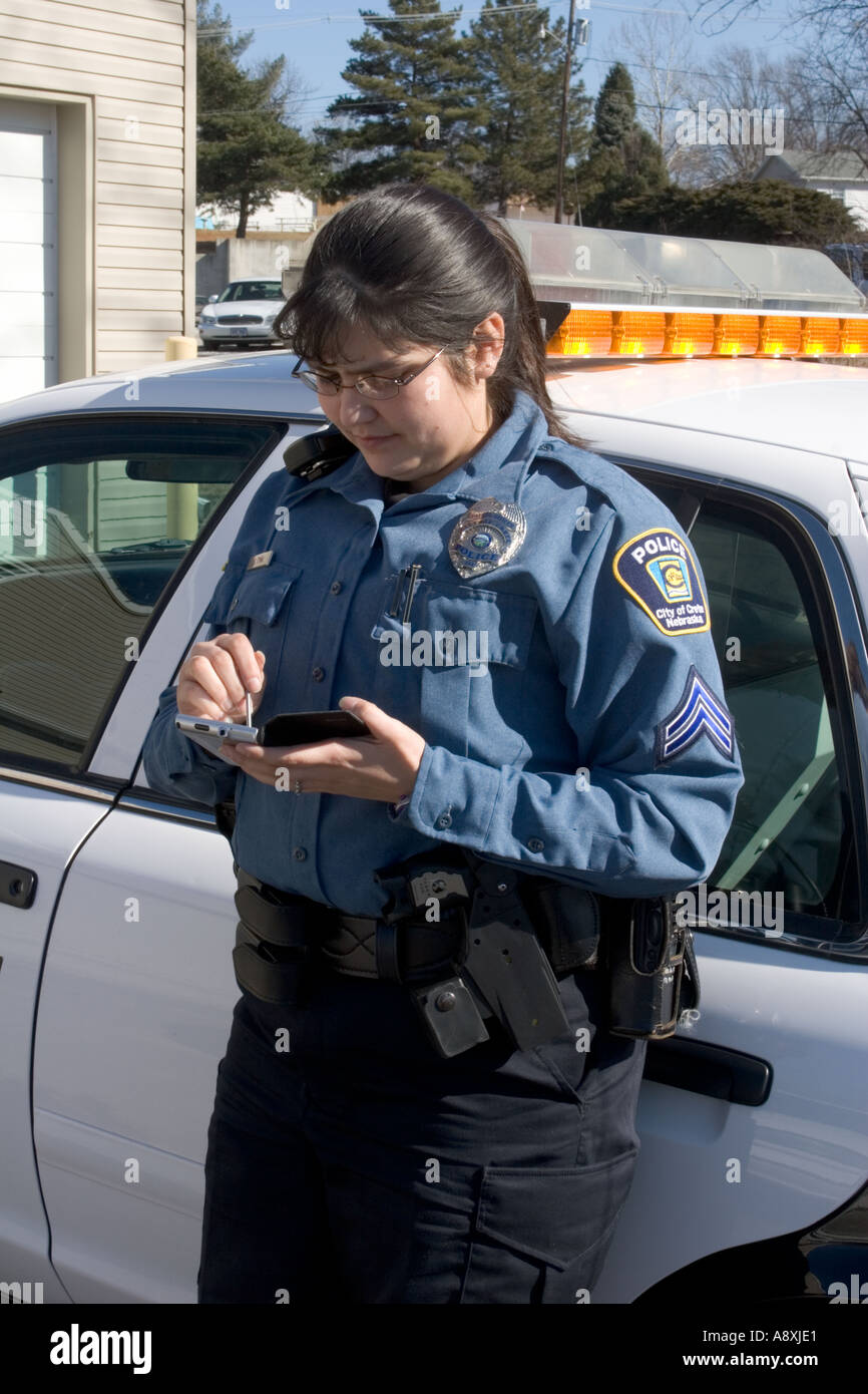 Female police officer using PDA hand held computer Crete Police Stock
