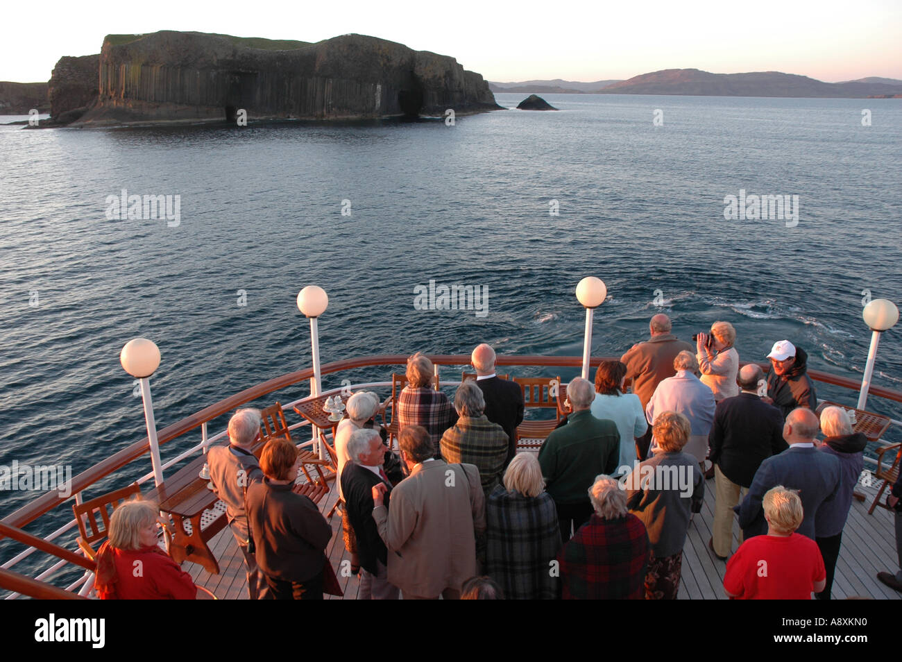 Luxury cruise ship Hebridean Princess pays a sunset call on Fingal's Cave Stock Photo