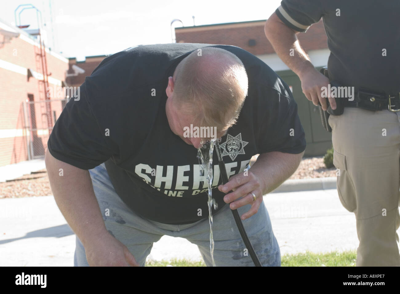 Sheriffs deputy rinsing his eyes after having been sprayed with pepper spray during training Saline County Sheriff s Office Stock Photo