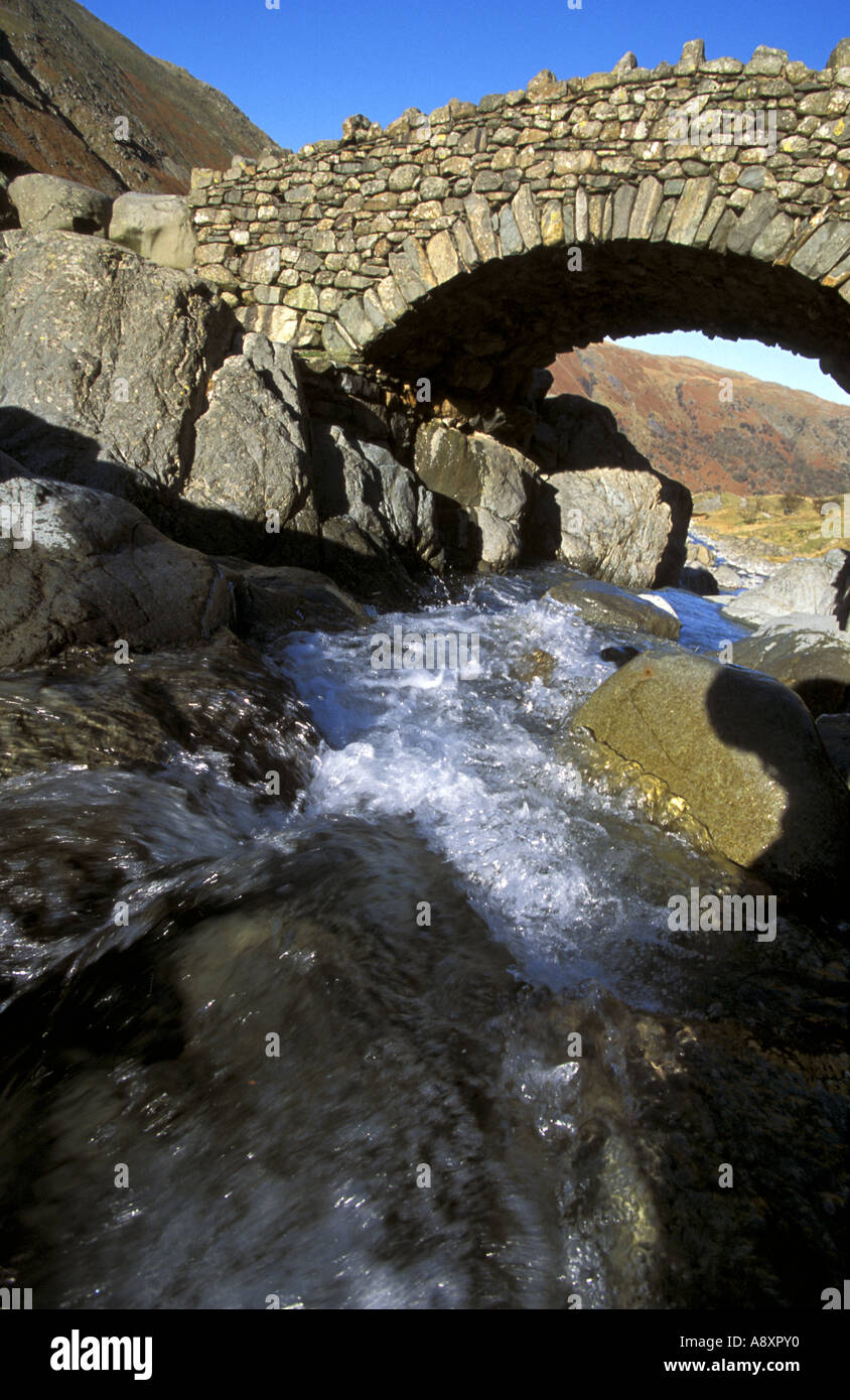 Footbridge over Grains Gill near Seathwaite in Borrowdale Cumbria A naturally running clean mountain stream Stock Photo