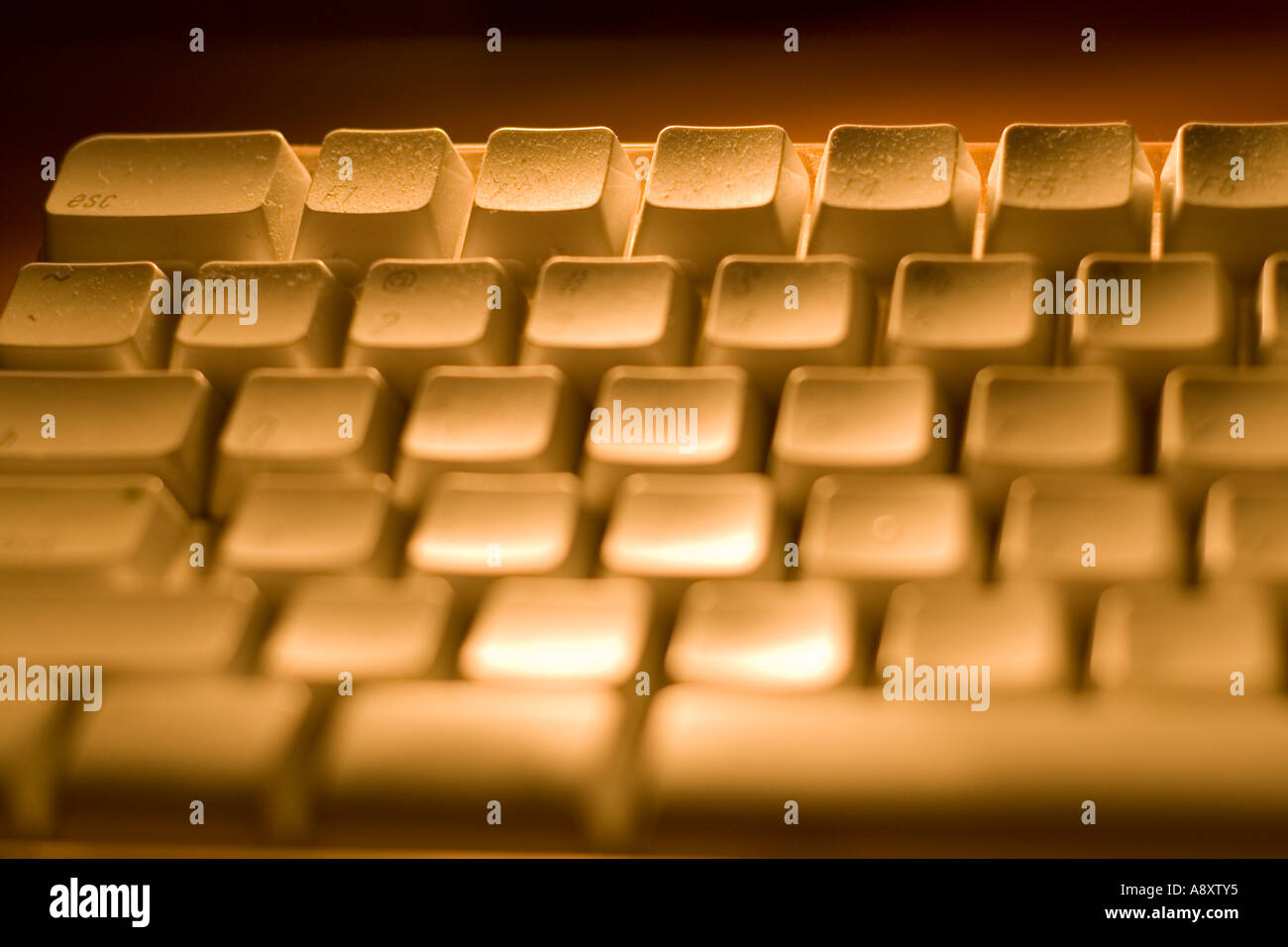 Close up of a illuminated keyboard, orange light, with shallow dept of field Stock Photo