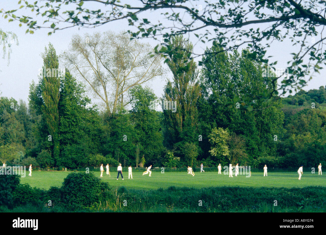 Local cricket teams play in riverside meadow in the town of Winchester, Hampshire, England, UK. Stock Photo