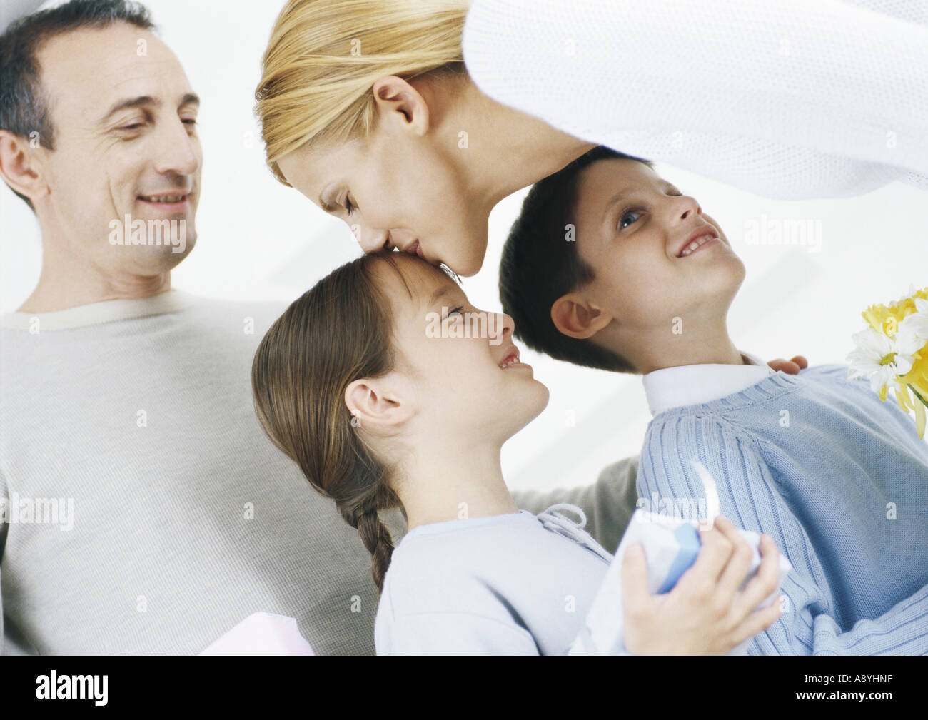 Family scene, mother kissing daughter on head Stock Photo