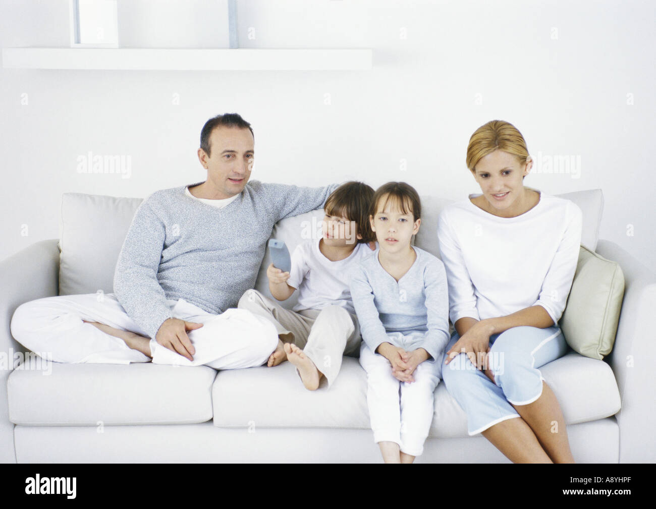 Family sitting on sofa together Stock Photo