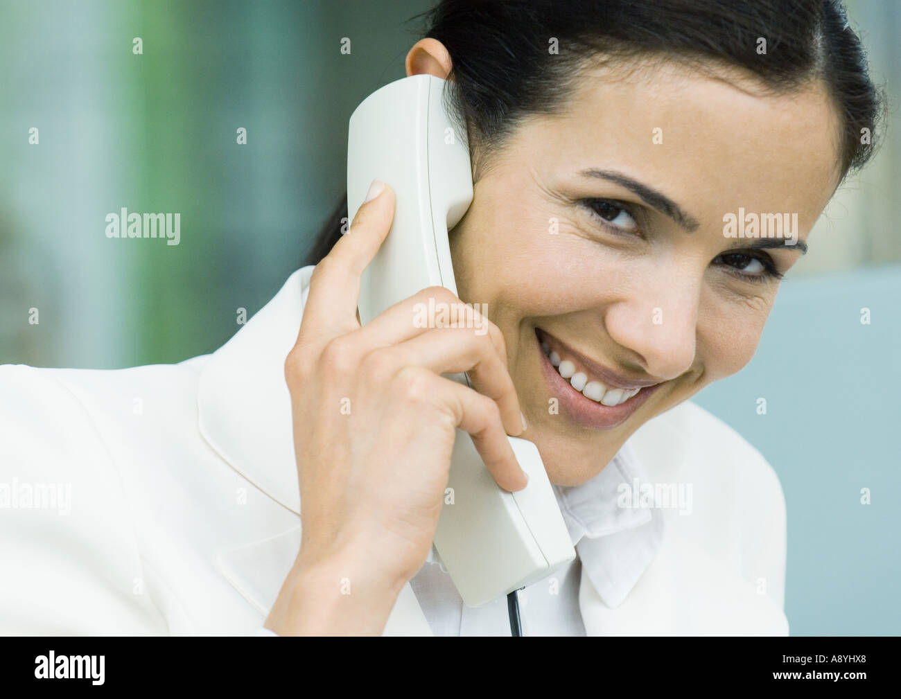 Businesswoman using landline phone Stock Photo - Alamy