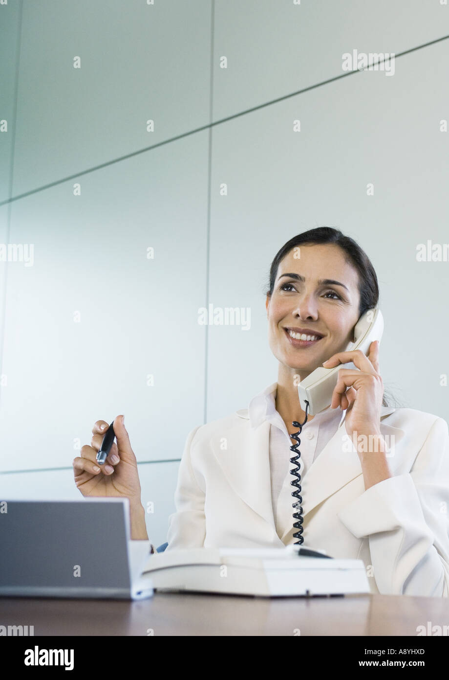 Businesswoman using landline phone Stock Photo - Alamy