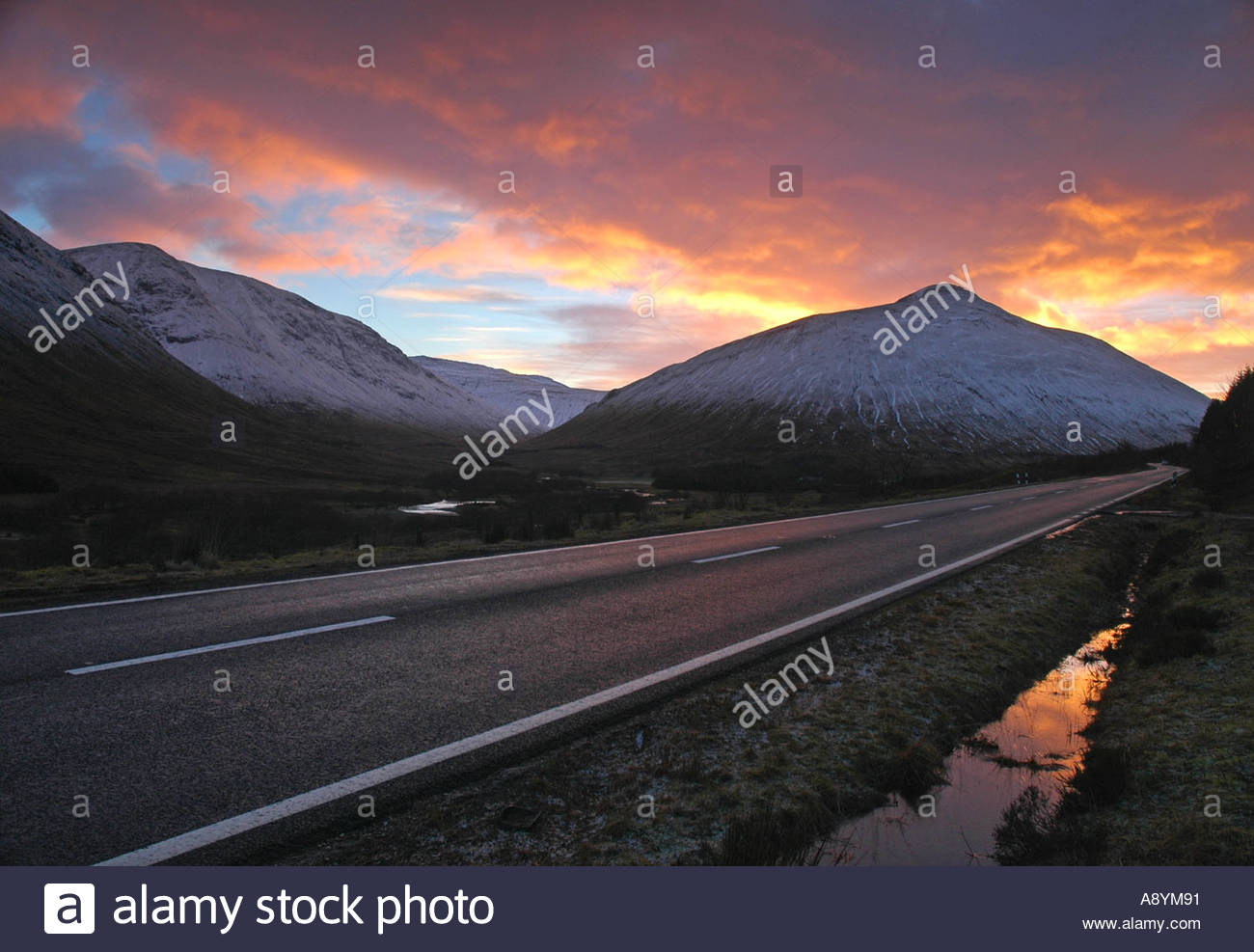 An early morning winter sunrise on the A82 road to Rannoch moor Scotland Stock Photo
