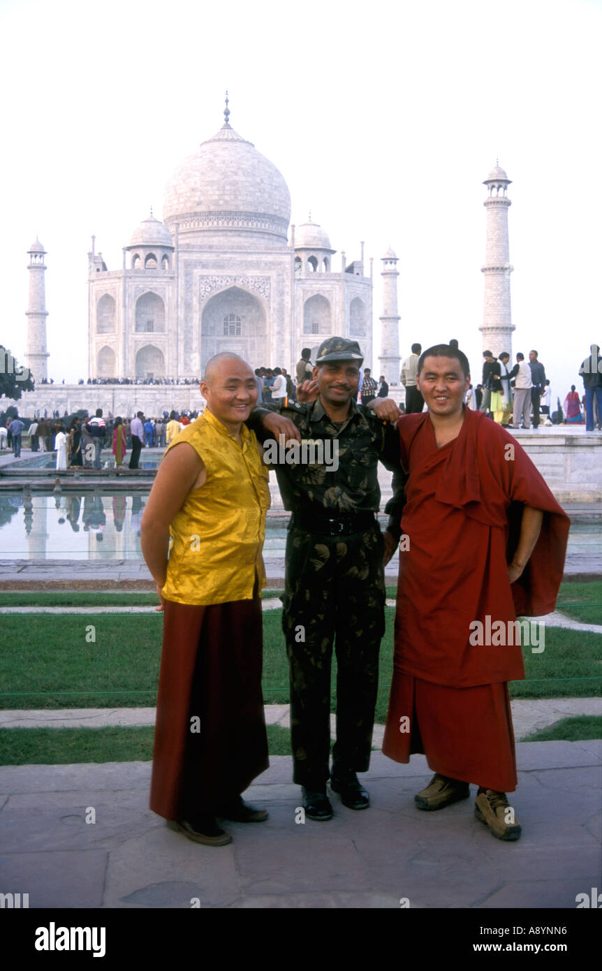 Three men pose for a picture in front of the Taj Mahal Agra India Stock