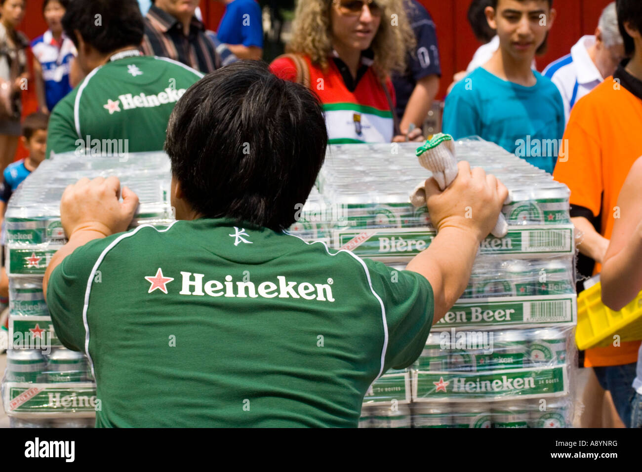 Heineken Employee Pushing Many Cases of Cans of Beer Stock Photo