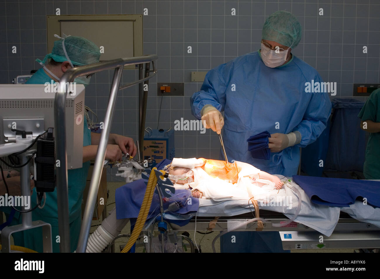 surgeon preparing two month old baby patient for heart surgery in operating room Stock Photo