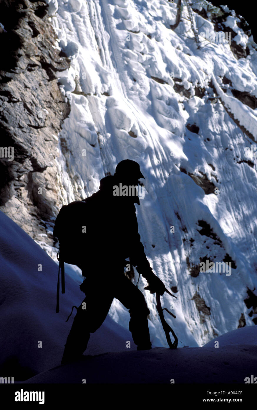 Silhouette of a mountaineer with his ice pick and back pack in the