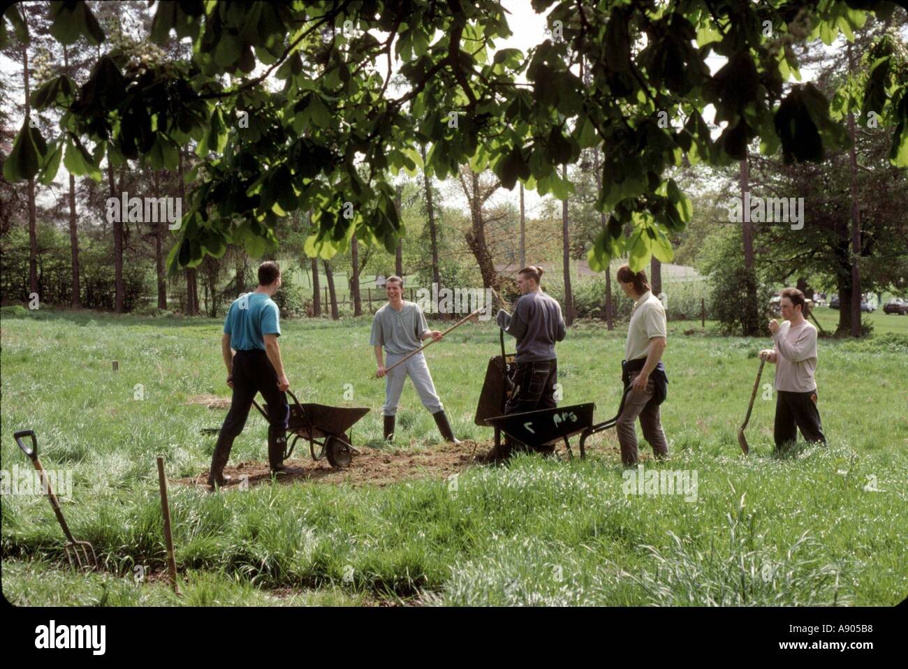 Young offenders on probation work doing gardening Stock Photo