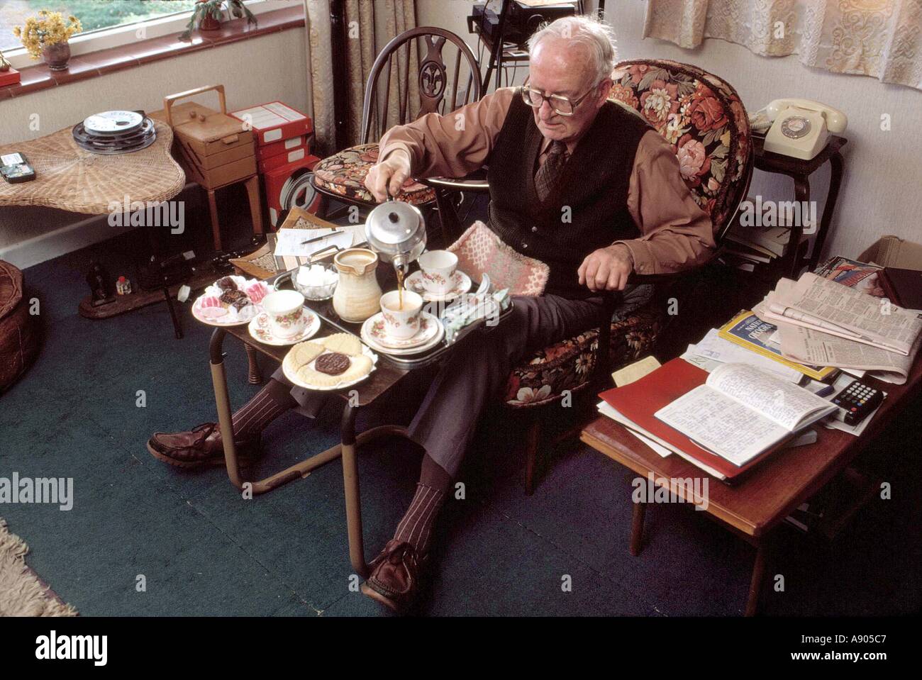 old man having afternoon tea and cakes at home Stock Photo