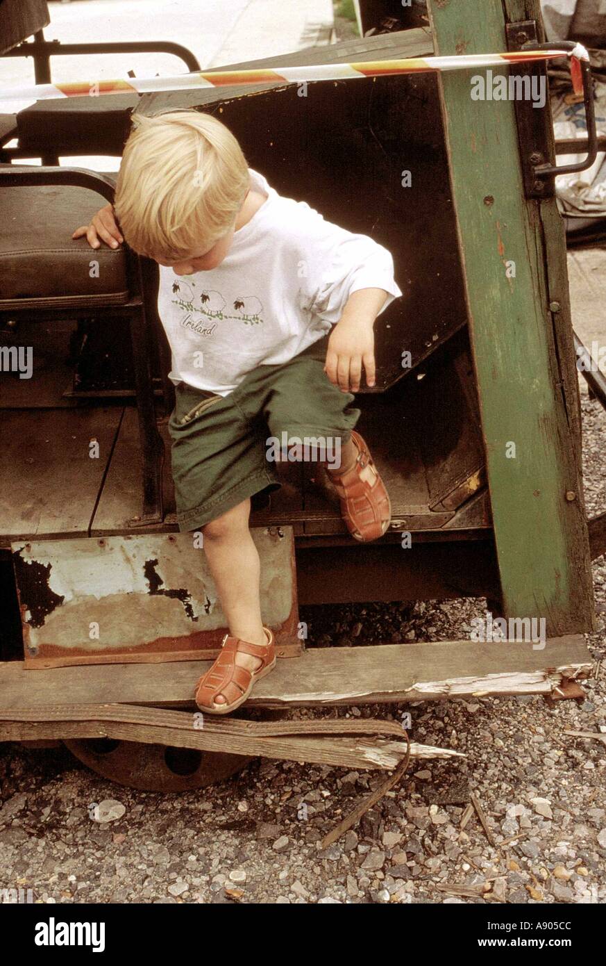 young boy climbing down old train Stock Photo