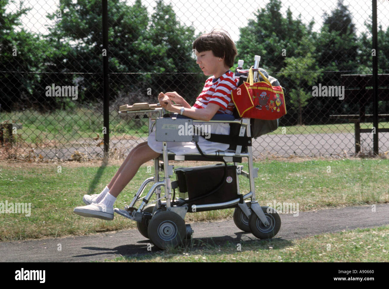 Disabled girl in motorized wheelchair in park Stock Photo