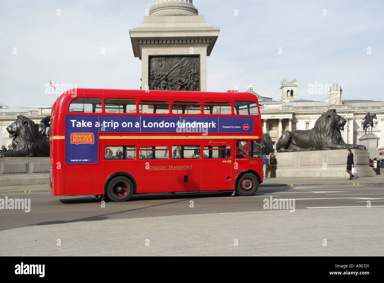 Trafalgar Square close up of red Routemaster double decker bus route 15 advert promoting Heritage Route Nelson Column beyond London England UK Stock Photo