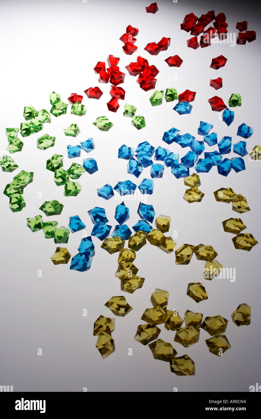 Scattered assorted colored acrylic pieces against white background