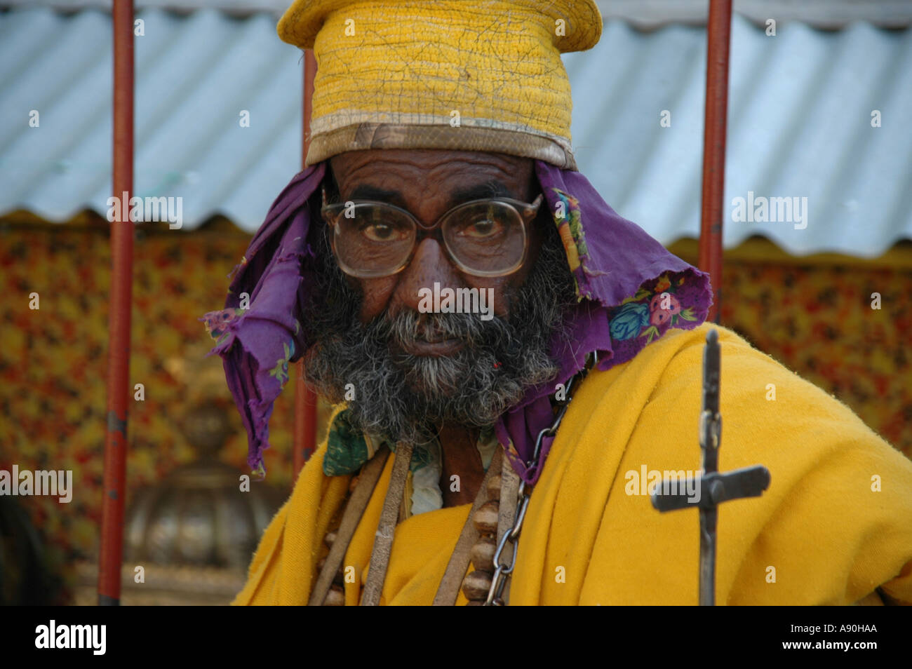 Character old priest in yellow cape with glasses Old Cathedral Aksum Ethiopia Stock Photo