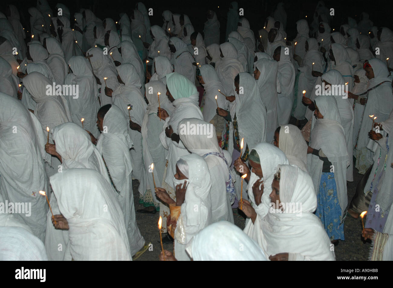Procession at nighttime of ethiopiean orthodox believers in white capes with candles Aksum Ethiopia Stock Photo