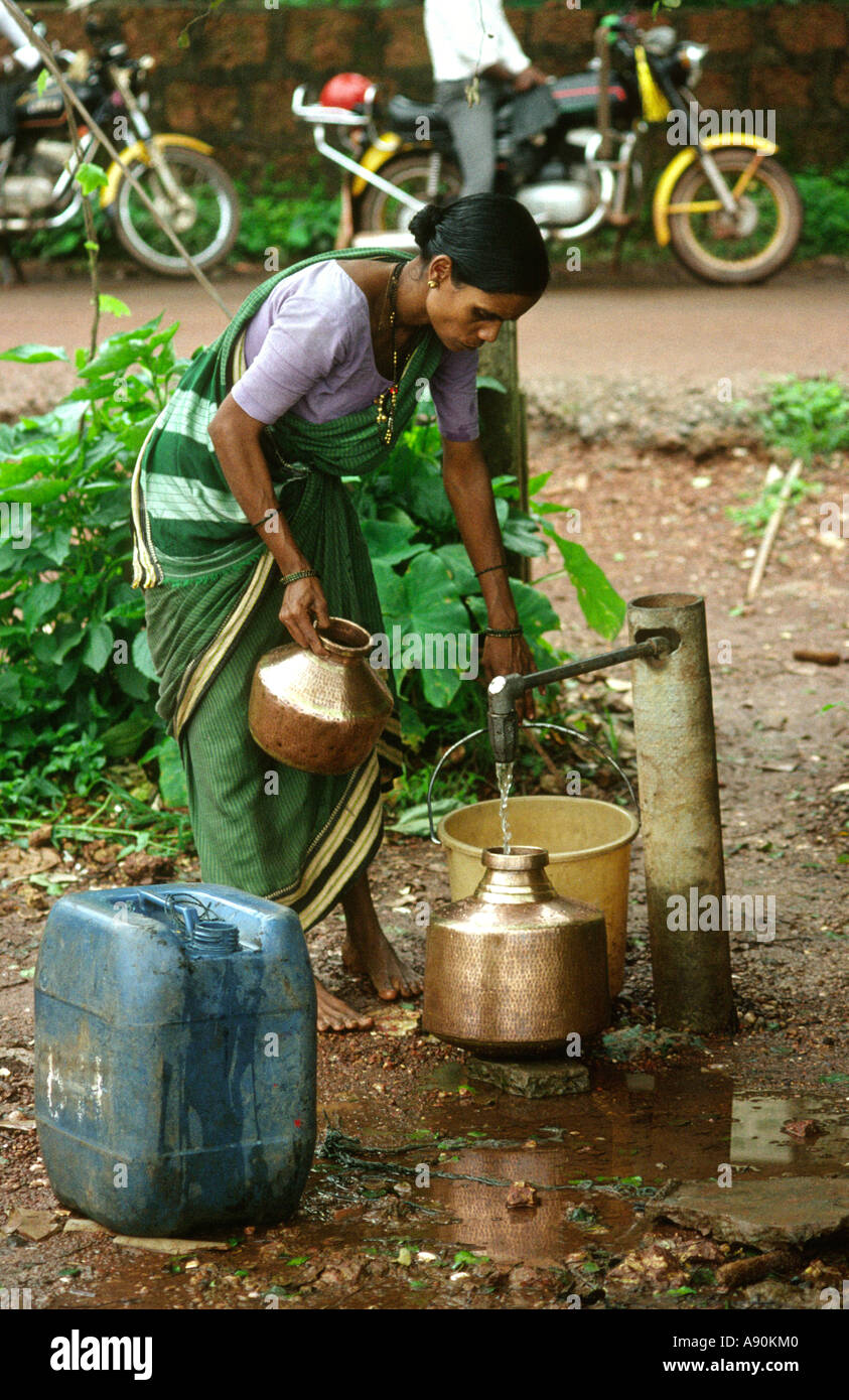 India Goa Panaji woman filling brass water container Stock Photo