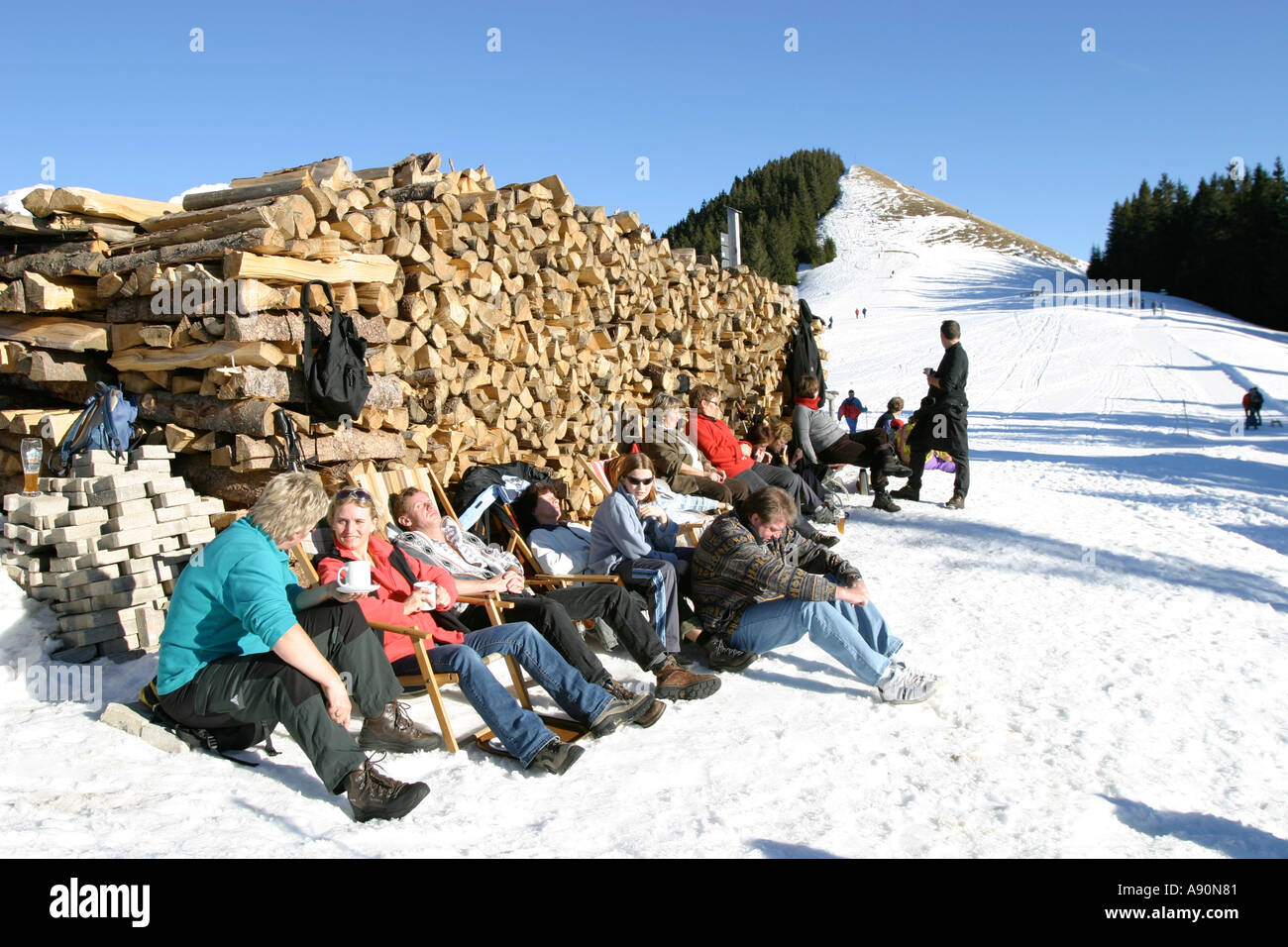 Sportsman and holidaymaker are sitting in the sun nearby the mountains station in the skiing area of Bad Kohlgrub Bavaria Stock Photo