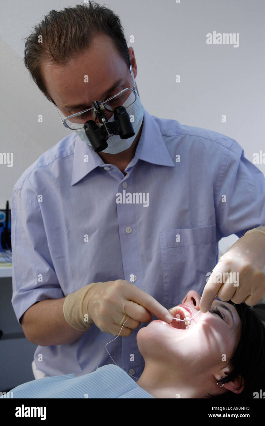 Cleaning teeth with dental floss - Zahnreinigung mit Zahnseide Stock Photo