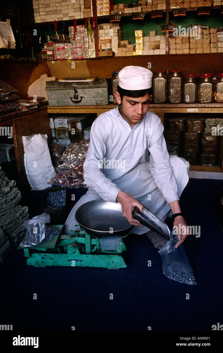 Pakistan NWFP Darra Adam Khel boy weighing out bullets Stock Photo