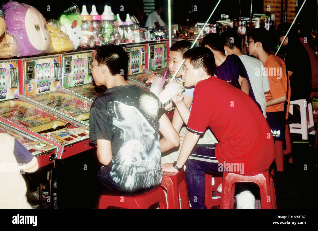 Chinese Teenager Playing Arcade Pachinko Pinball Game Stock Photo