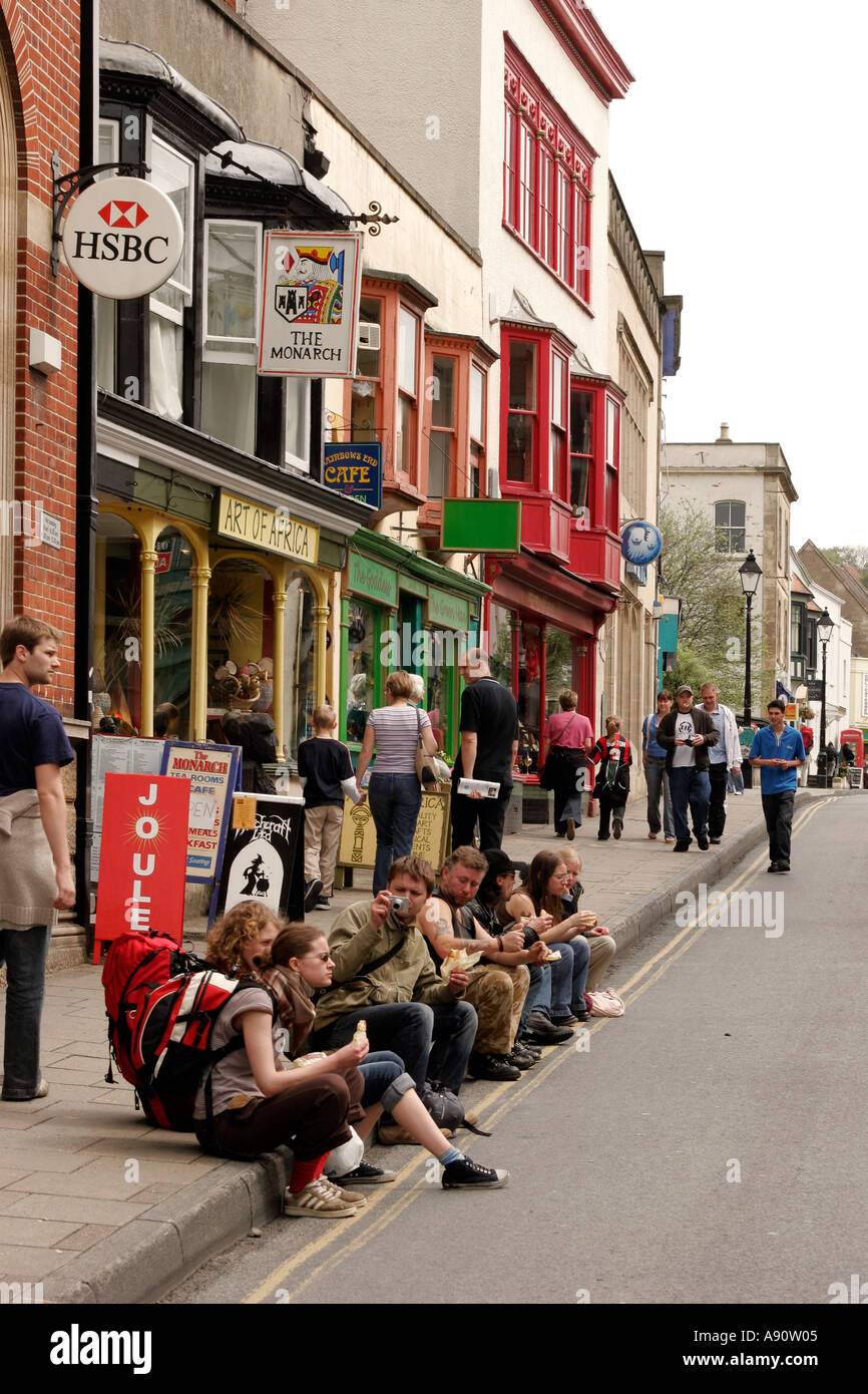 England Somerset Glastonbury High Street backpackers sat on pavement