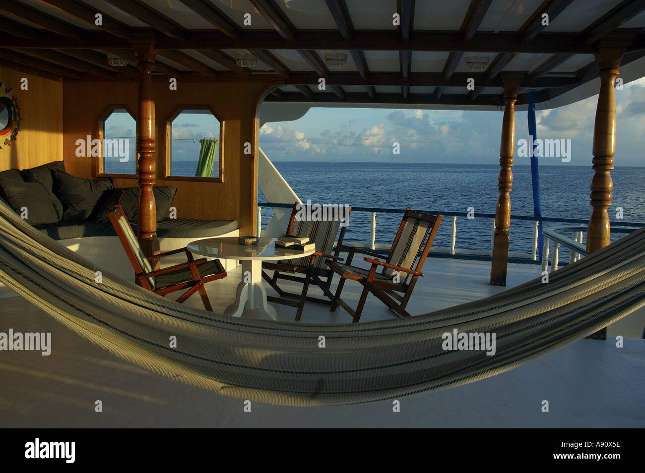 Hammock and outdoor furniture on a cruising diver's luxury boat, Maldives at dusk Stock Photo