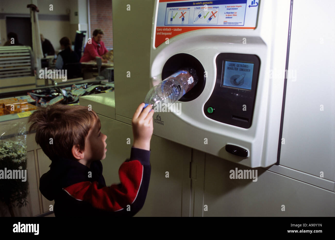 A youngster recycling plastic bottles in an automatic bottle bank