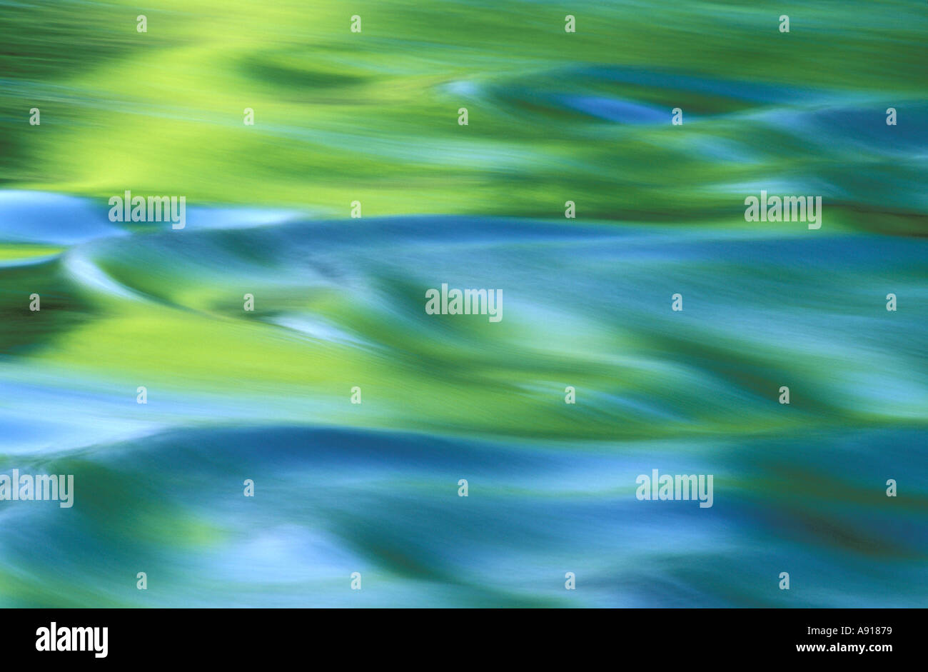 Green and blue color reflecting in flowing water Stock Photo