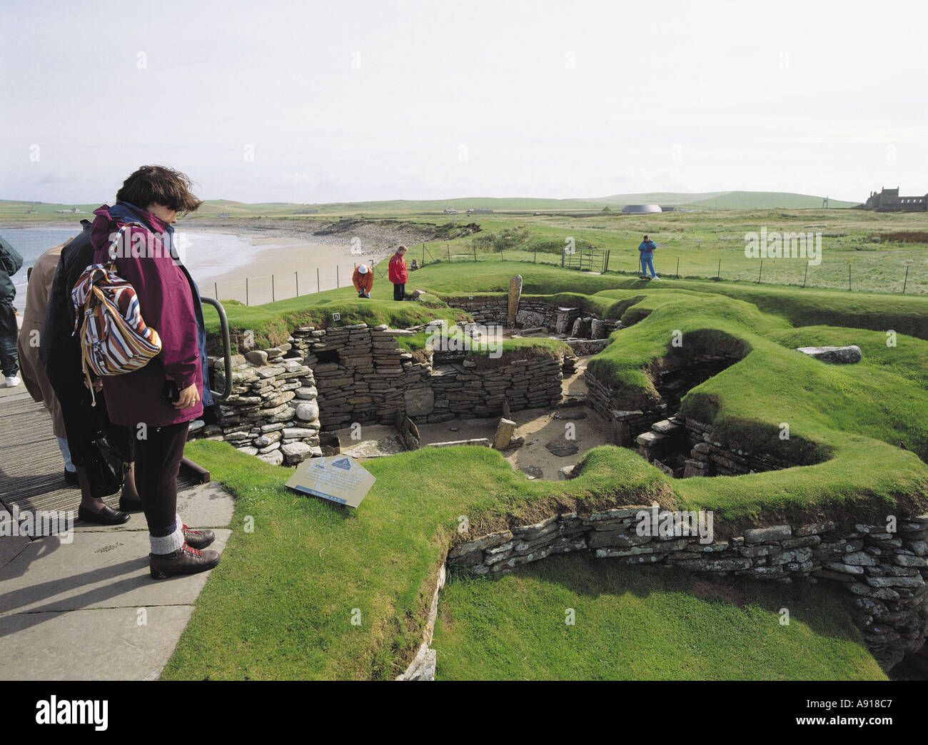 dh Bay of Skaill SKARA BRAE ORKNEY Girl tourist prehistoric neolithic settlement house ruins tourists scotland bronze age buildings village britain Stock Photo