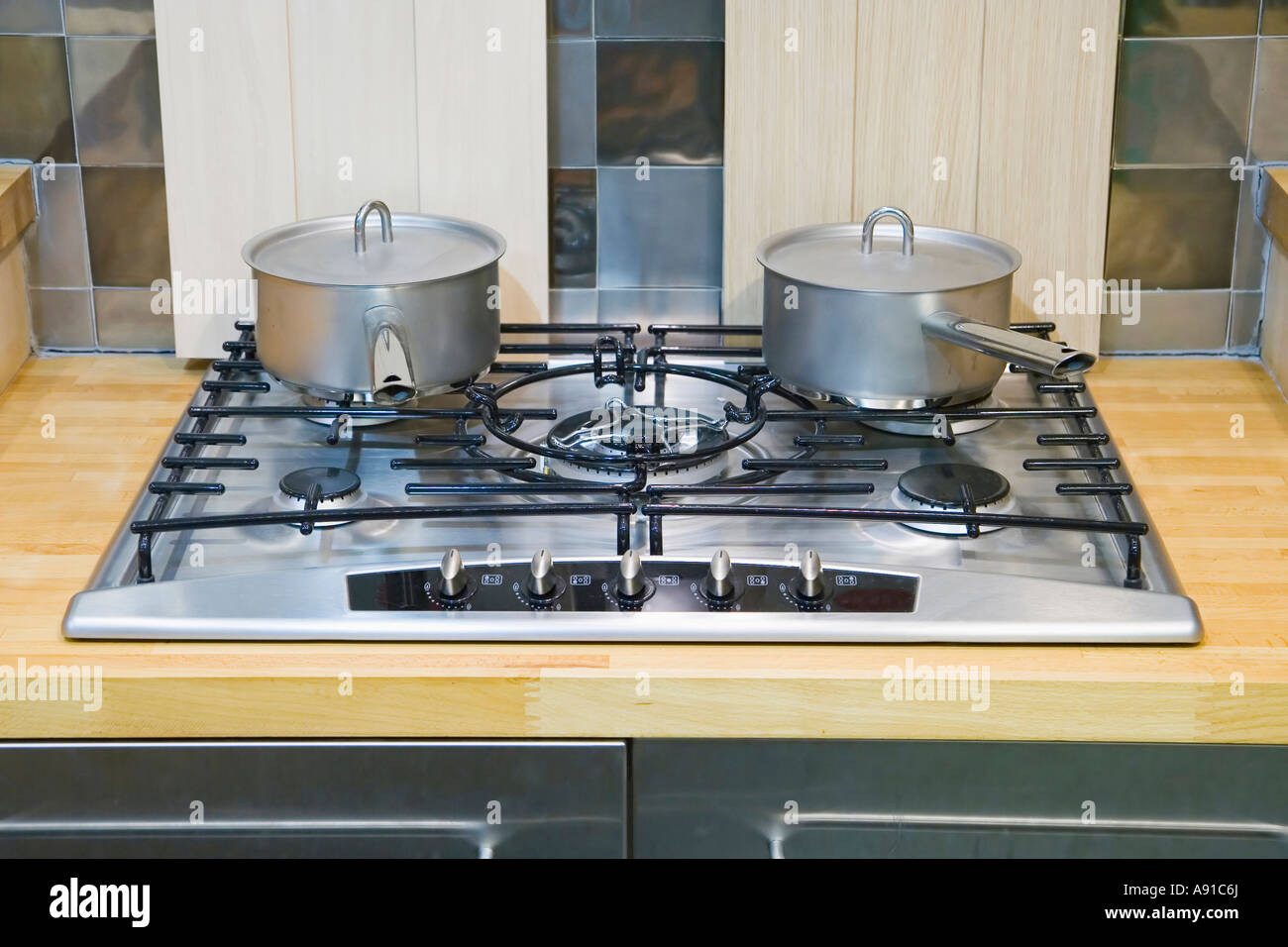 Two saucepans with lids on a gas hob Stock Photo Alamy