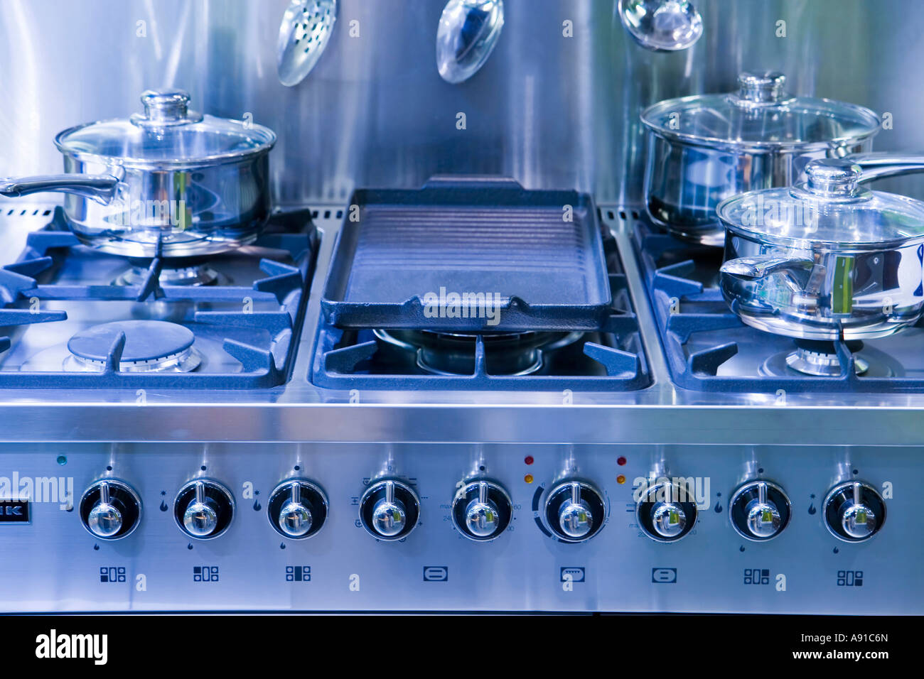 A new gas hob tinted blue with saucepans Stock Photo Alamy