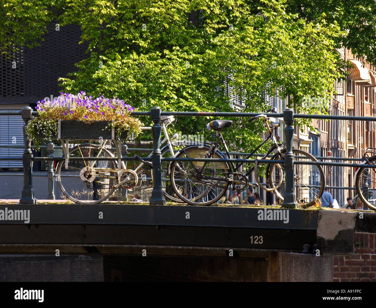 Niederländische Fahrräder auf eine Brücke mit Blumen in Amsterdam Dutch bicycles at a canal bridge with flowers in Amsterdam Stock Photo