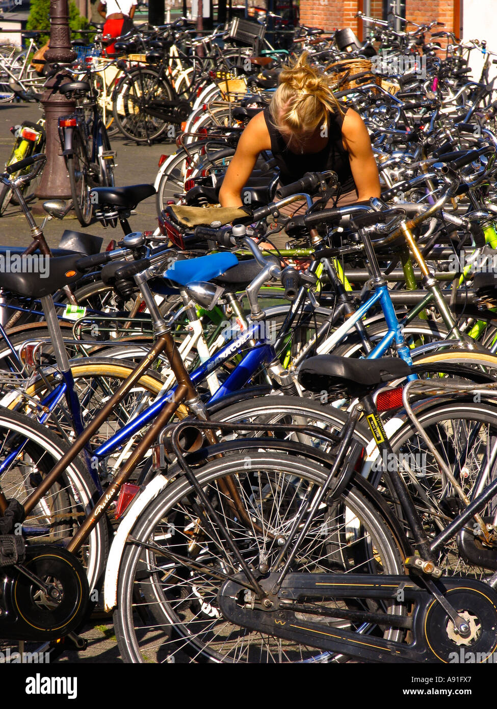 Young woman at a row of Dutch bicycles in Amsterdam Stock Photo