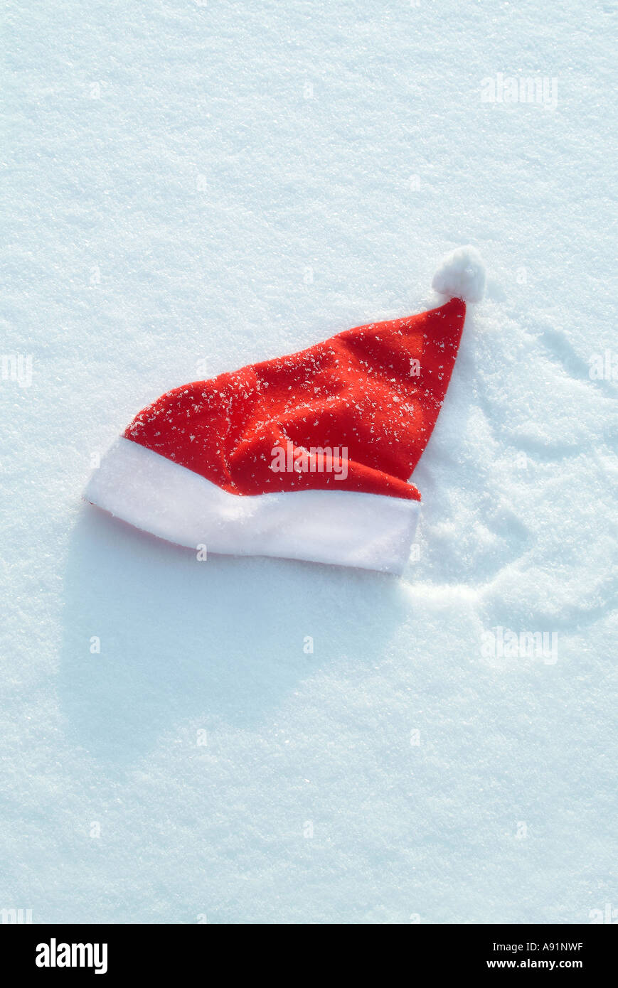 red Santa Claus Cap in the snow Rote Nikolausmuetze im Schnee Stock Photo