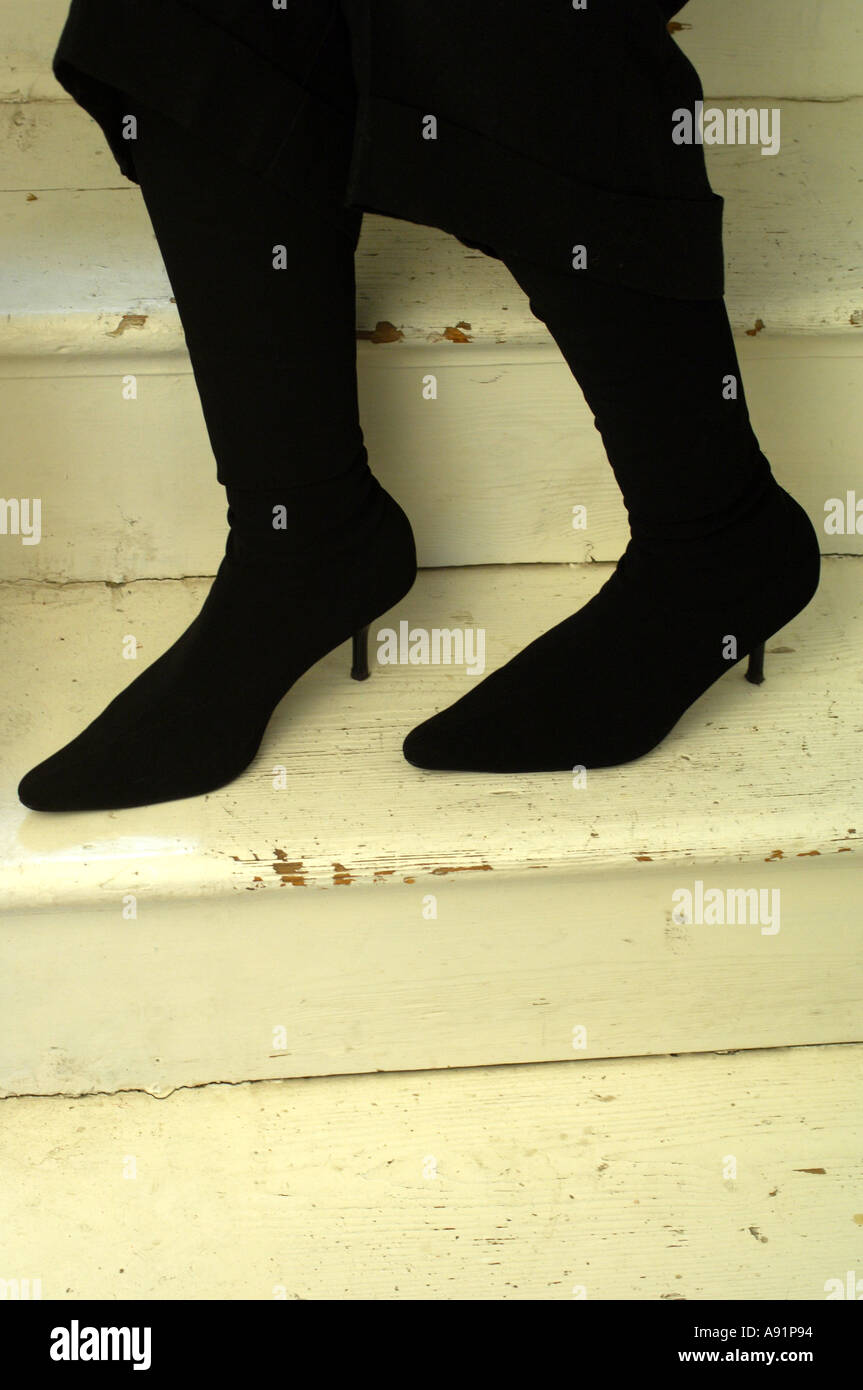 Young womans trendy legs and boots on the stairs Stock Photo