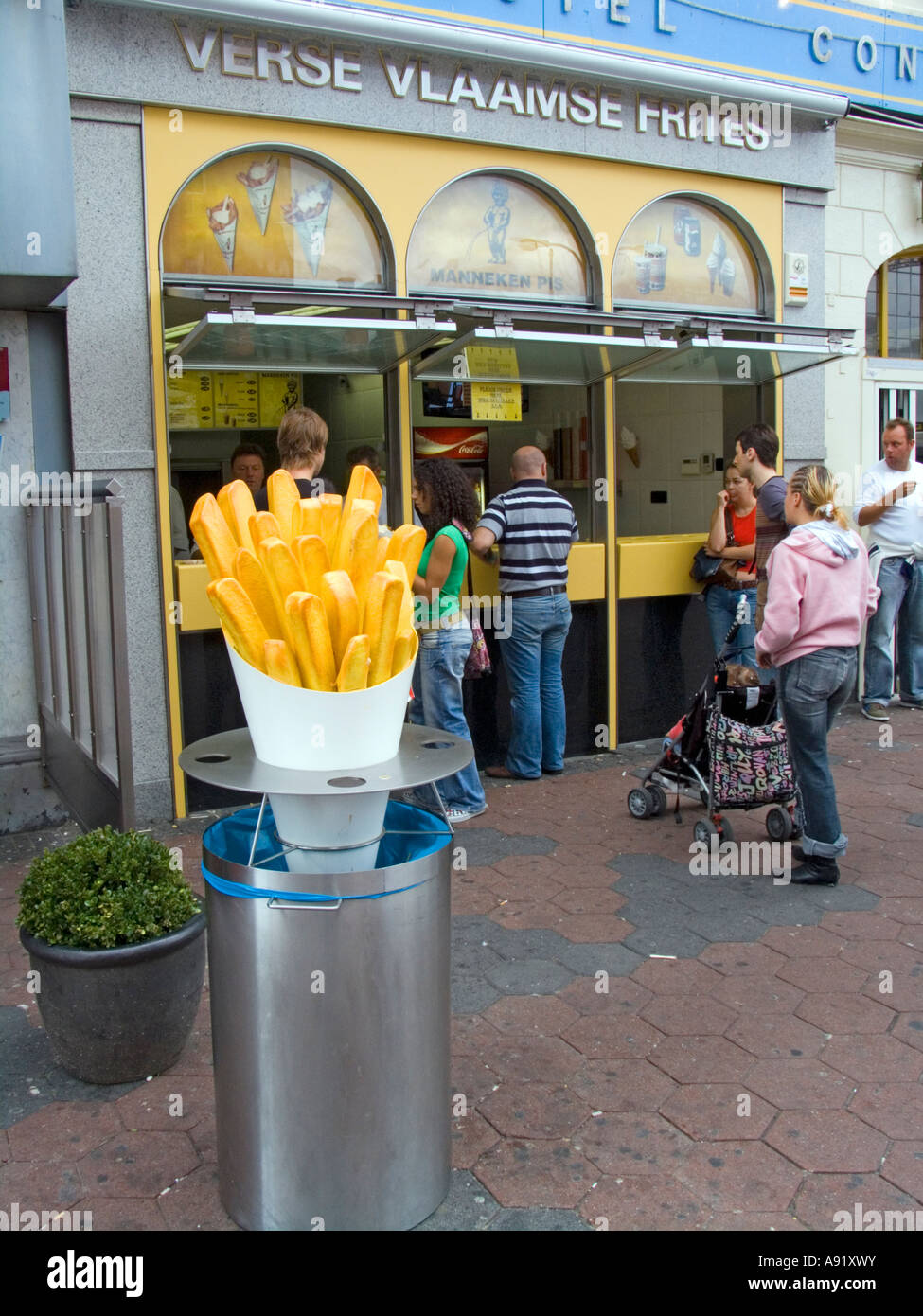 Customers queue for paper cones of fresh chips and mayonnaise Damrak