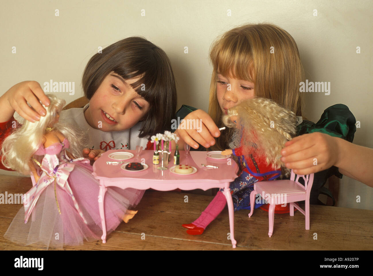little girls playing with barbie dolls