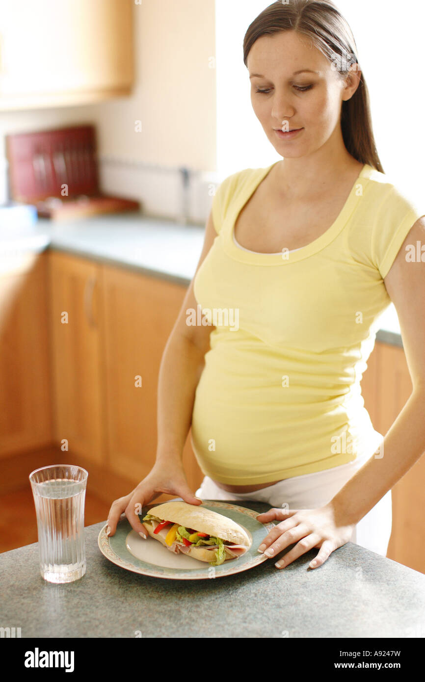 Pregnant woman eating sandwich Stock Photo Alamy