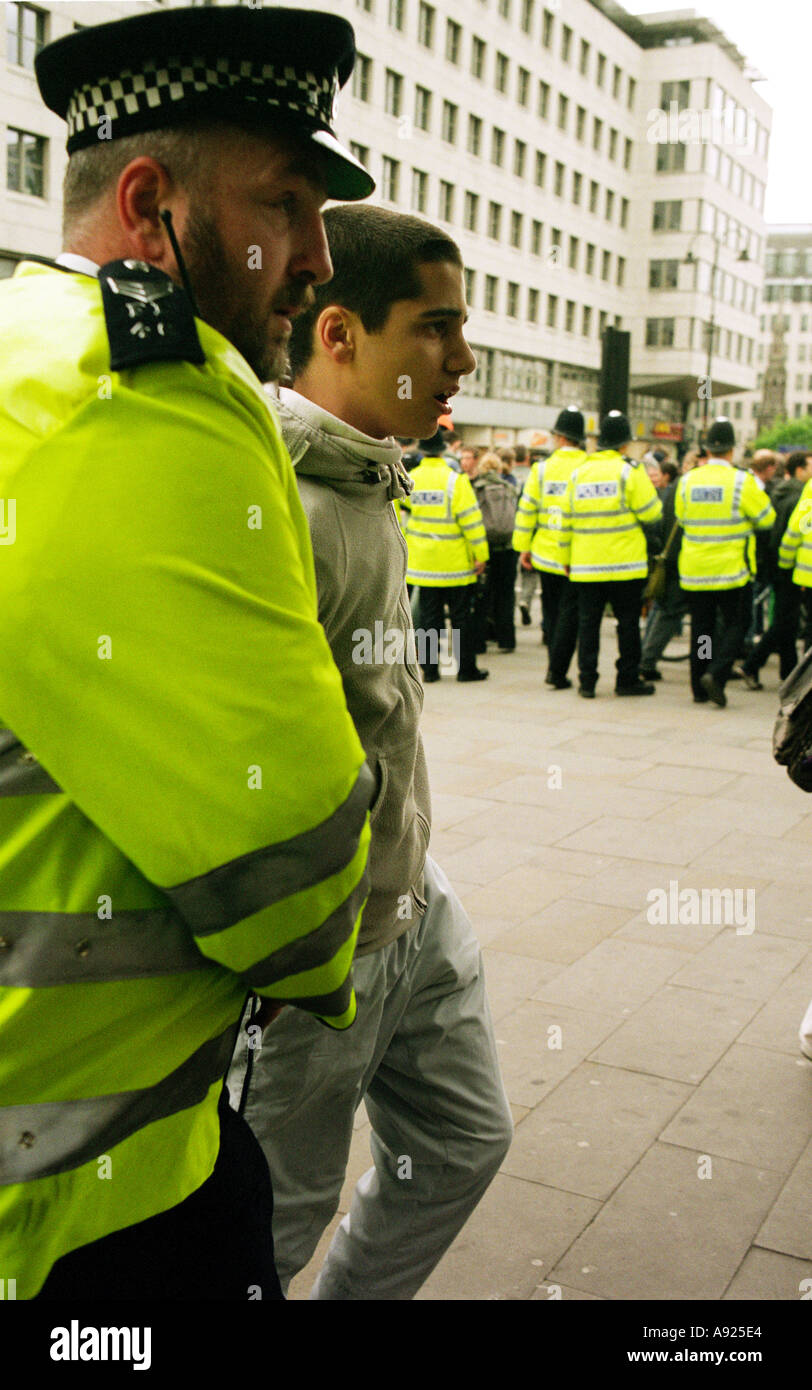 Police officers arresting a young man at a demonstration in central London,  Mayday 2003. Stock Photo