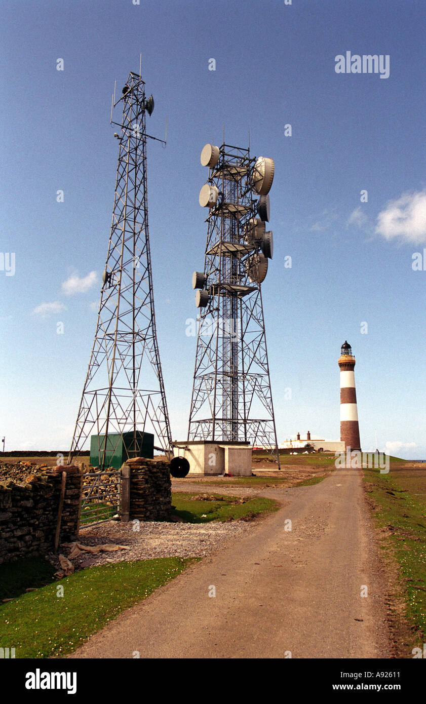 Lighthouse flanked by telephone and communication masts on North Ronaldsay Orkney Scotland Stock Photo