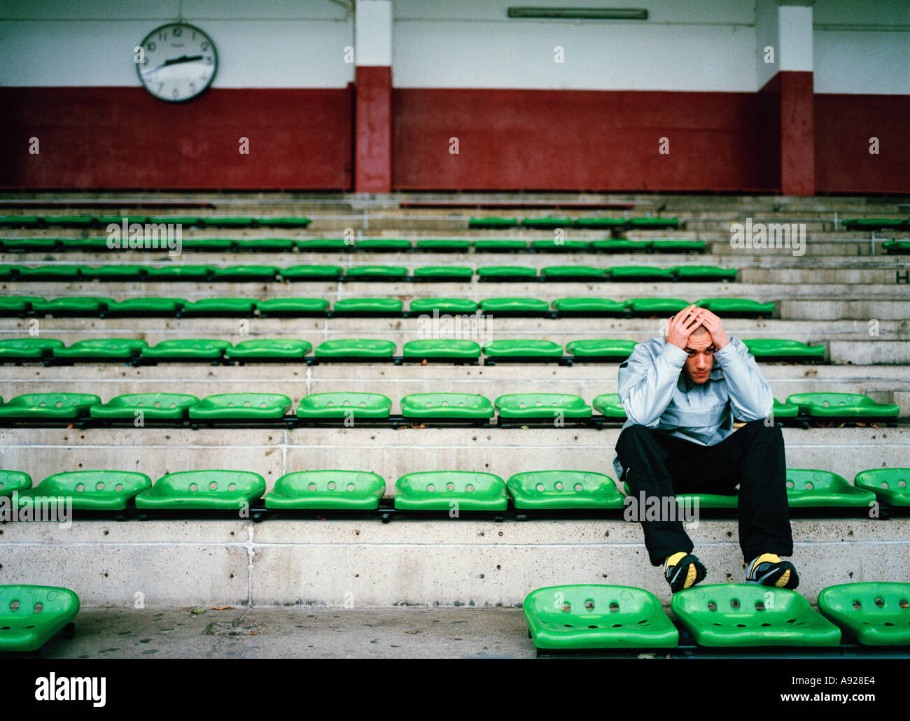 SAD LONELY YOUNG MAN IN STADIUM Stock Photo